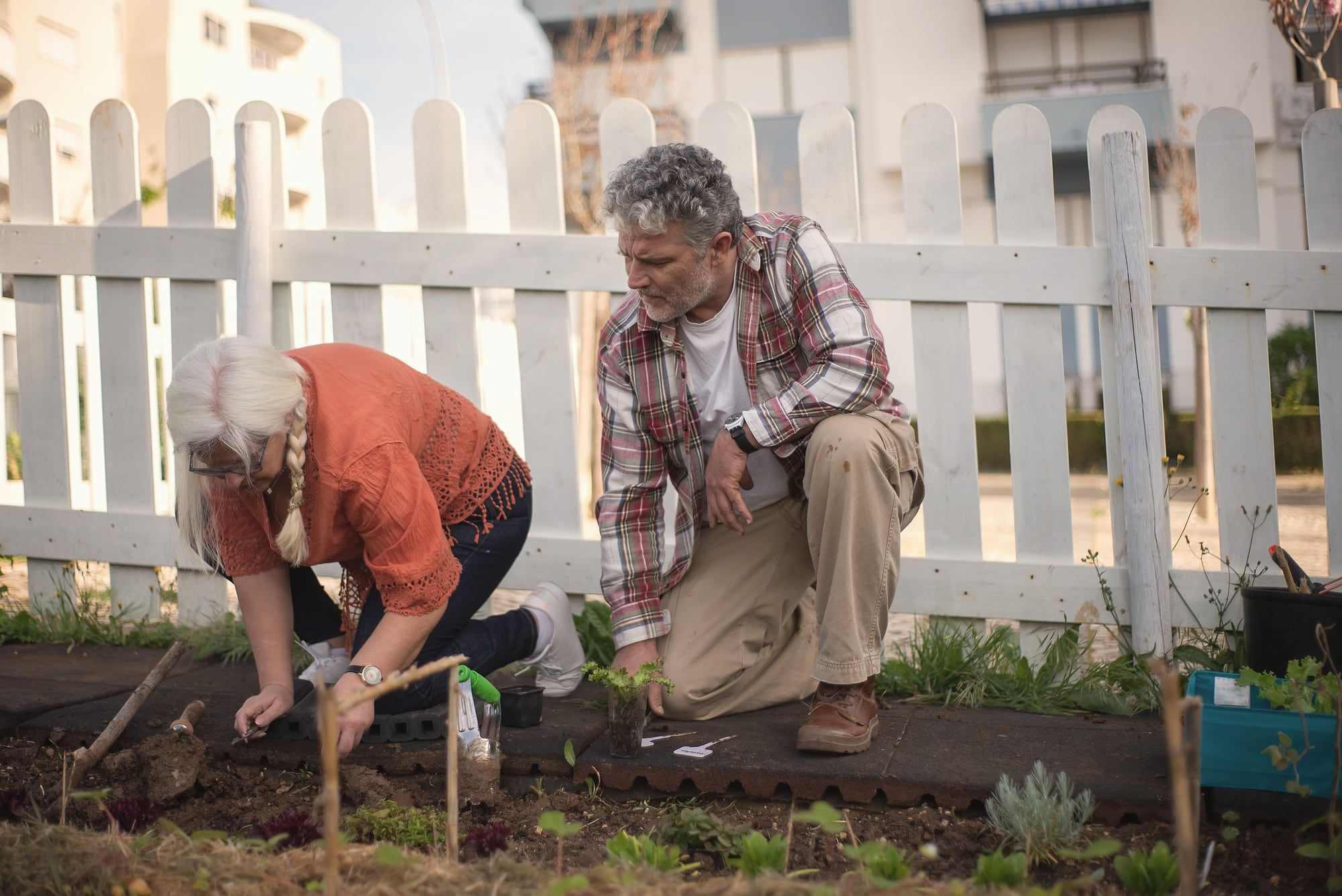 Un couple de retraités travaille dans son potager.